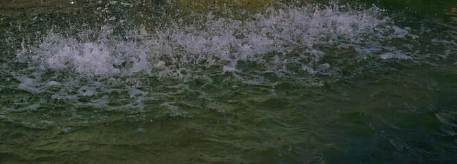 Jets of water flowing from the bowl of the fountain close-up. Sunny day.