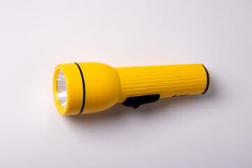 A yellow flashlight on a white background