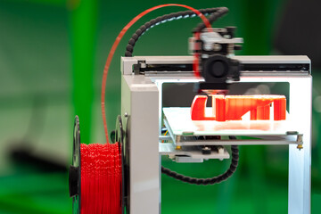 3d printer. Printer for bulk printing. A machine for printing three-dimensional objects. Three-dimensional images in red are printed. The printer is equipped with red printing material.