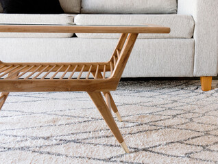 Primer plano de mesa de madera de estilo escandinavo aislada en confortable y brillante ambiente de un departamento © Pablo