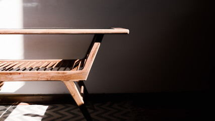 Primer plano de parte de una mesa de madera de estilo escandinavo aislado en una habitación iluminada por la luz del sol  © Pablo