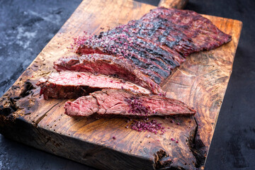 Barbecue wagyu bavette beef steak with red wine salt offered as close-up on an old rustic wooden...