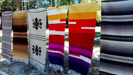 colorful handmade woven carpets hang at the fair