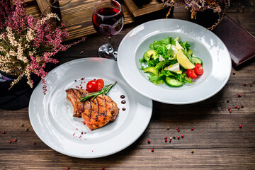 Two dishes on a wooden table - steak and salad. Set of food for lunch