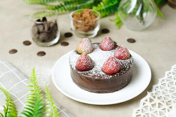 Mousse chocolate cake with strawberry and icing powder sugar. set on cafe table.
