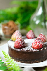 Mousse chocolate cake with strawberry and icing powder sugar. set on cafe table.