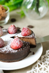 Mousse chocolate cake with strawberry and icing powder sugar. set on cafe table.