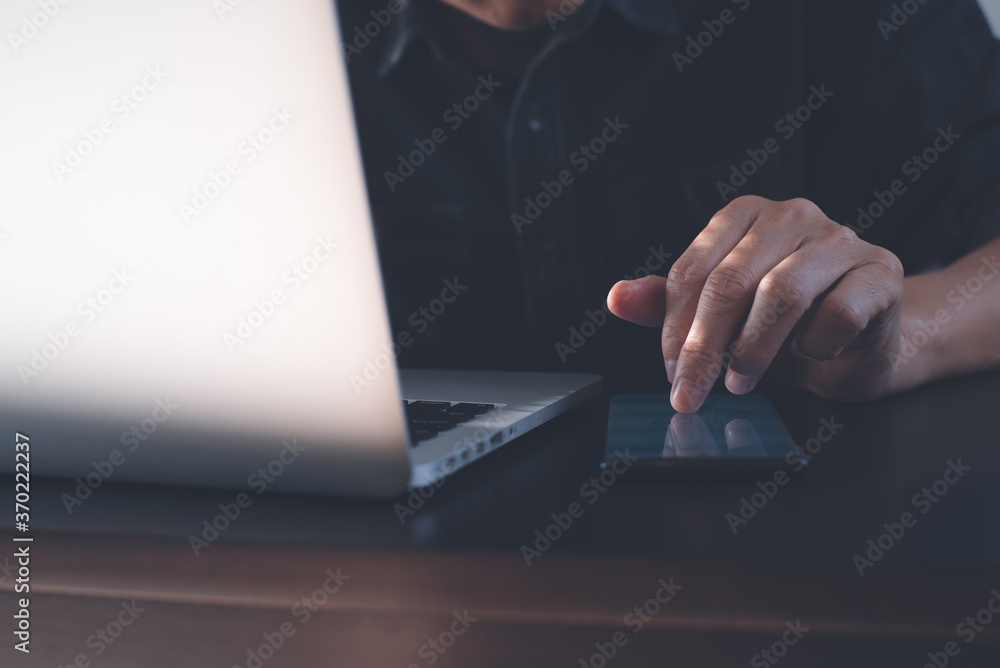 Poster man online working on laptop computer and using mobile phone on table