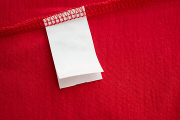 White laundry care washing instructions clothes label on red cotton shirt