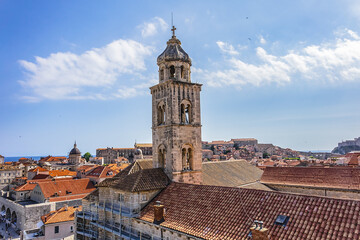 Fototapeta premium Church tower of Dominican Monastery (Dubrovnik Dominikanski Samostan, 1225) and the orange-tiled roofs of old town. Dubrovnik, Mediterranean, Croatia.