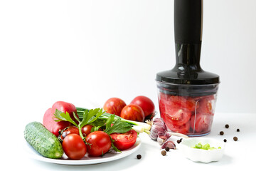 Vegetables on a white faded background. the process of preparing Spanish cold gazpacho soup....