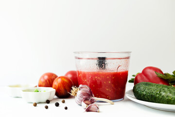 Vegetables on a white faded background. the process of preparing Spanish cold gazpacho soup....