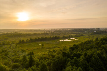 panoramic landscape of lake and forest around in summer at dawn filmed from a drone
