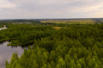 panoramic landscape of lake and forest around in summer at dawn filmed from a drone