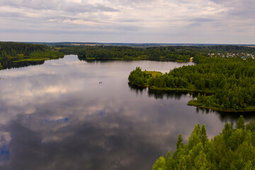 Fototapeta na wymiar panoramic landscape of lake and forest around in summer at dawn filmed from a drone
