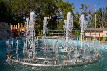 Bright Sunny day in the Children's Park.Several jets of the fountain shot up.