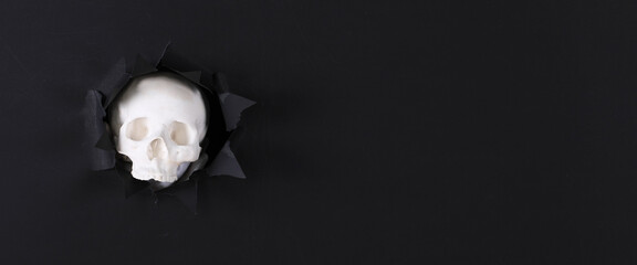 skull in black paper hole