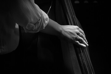 mano tocando un cello en blanco y negro