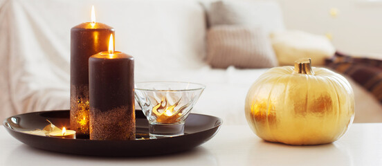home decor with golden pumpkin and burning candles