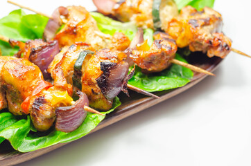 Grilled skewers with chicken, zucchini, mushrooms, peppers and onions served on iceberg lettuce