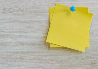 yellow stickers for notes on a wooden white textured background copy space
