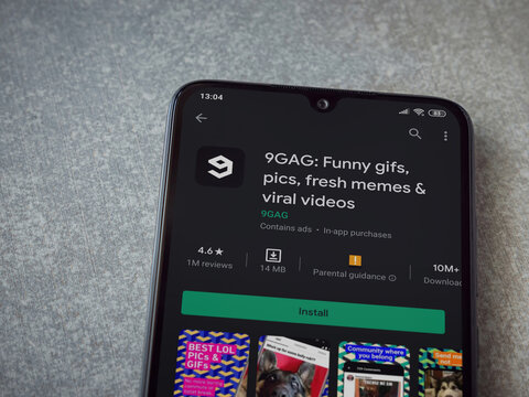 Lod, Israel - July 8, 2020: 9GAG app play store page on the display of a black mobile smartphone on ceramic stone background. Top view flat lay with copy space.