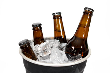 A black ice bucket with four brown glass bottles of beer on a white background.