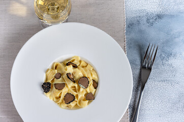 Dish of delicious italian pasta tagliatelle with truffle mushroom chips