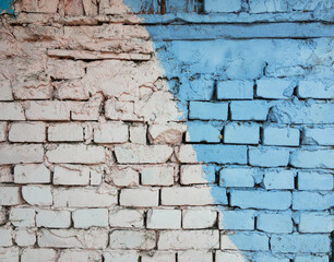 brick wall with a pronounced texture and part of it is painted in blue and white