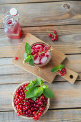 Glass jar of red currant soda drink on a wooden table. Summer healthy detox lemonade, cocktail or another drink background. Low alcohol, nonalcoholic drinks, vegetarian or healthy diet concept.