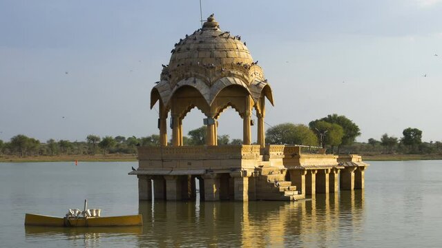 Yellow stone structures amidst water body, Gadisar lake in the beautiful city of Jaisalmer, was artificially built for water conservation. Shot at afternnon in Jaisalmer, Rajasthan, India