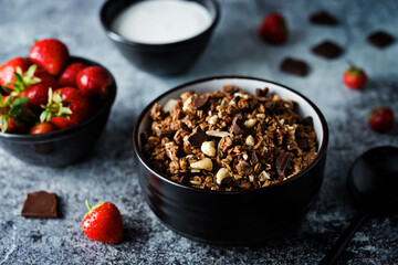 Chocolate nuts oatmeal granola with chocolate slices in a bowl