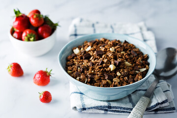 Chocolate nuts oatmeal granola with chocolate slices in a bowl