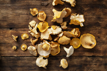 Chanterelle mushrooms scattered on a wooden table
