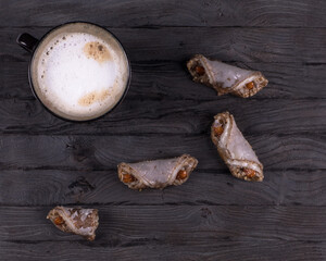 coffee and nut cookies on black wooden background