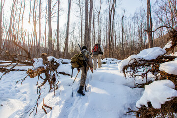 January, 2016 - Agzu, Primorsky Territory - Udege hunters with guns walk through deep snow in the...