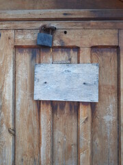 The sign on the old wooden door is not painted.