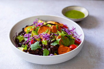 Vegan bowl with black beans, roast sweet potatoes, red cabbage and avocado
