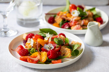 Summer panzanella salad with tomatoes, raspberries, basil and red onion