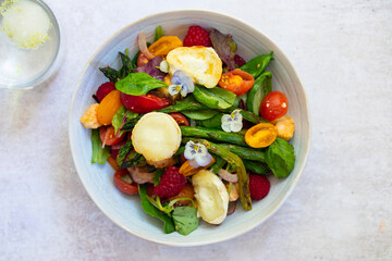 Summer panzanella salad with tomatoes, raspberries, basil and goat cheese