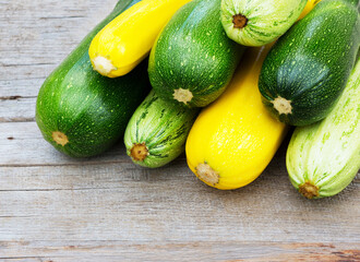 Zucchini on wooden background. Yellow and green zucchini.