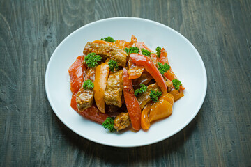 Bell pepper and meat salad. Asian food. Colorful hot salad. Dark background. Space for text.