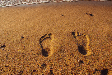 footprints in sand, on Mandraki beach, Skiathos, Greece