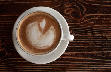 a white ceramic cup of cappucino as a coffee break concept