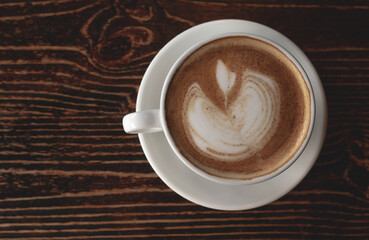a white ceramic cup of cappucino as a coffee break concept