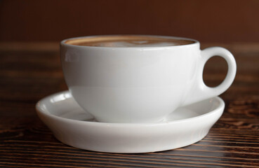a white ceramic cup of cappucino as a coffee break concept