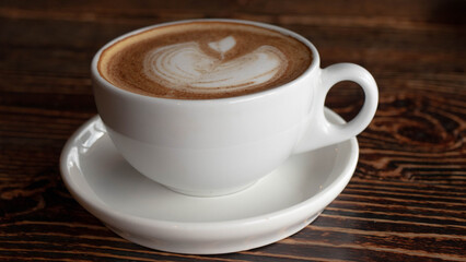 a white ceramic cup of cappucino as a coffee break concept