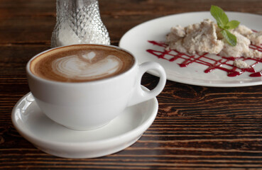 a white ceramic cup of cappucino as a coffee break concept