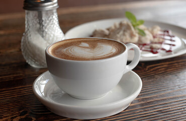 a white ceramic cup of cappucino as a coffee break concept
