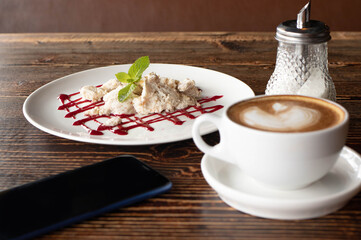 coffee cup, smartphone and dessert on wooden table